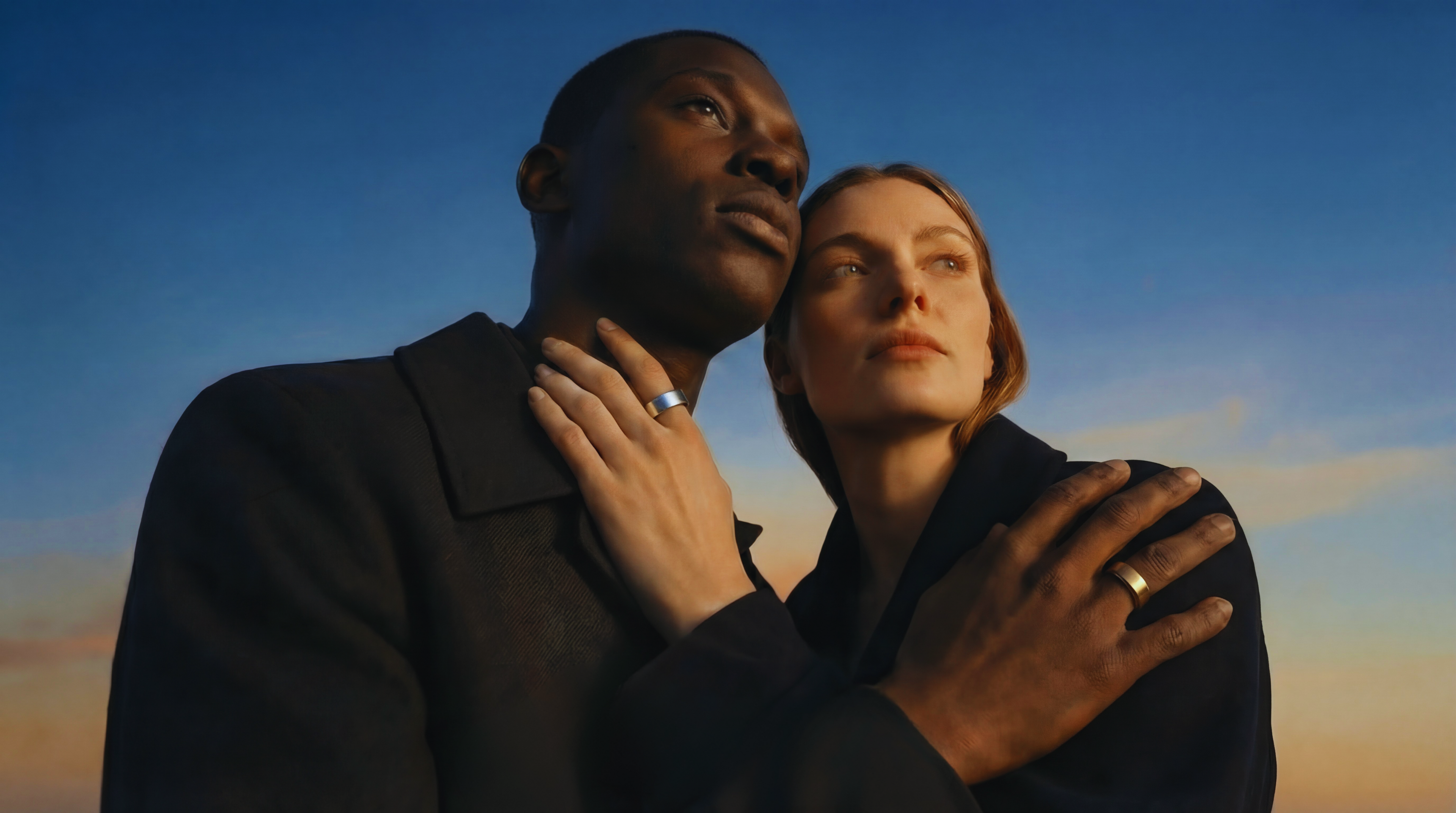 Couple wearing matching Synora smart rings at sunset. Unisex wearable technology for tracking sleep and wellness together